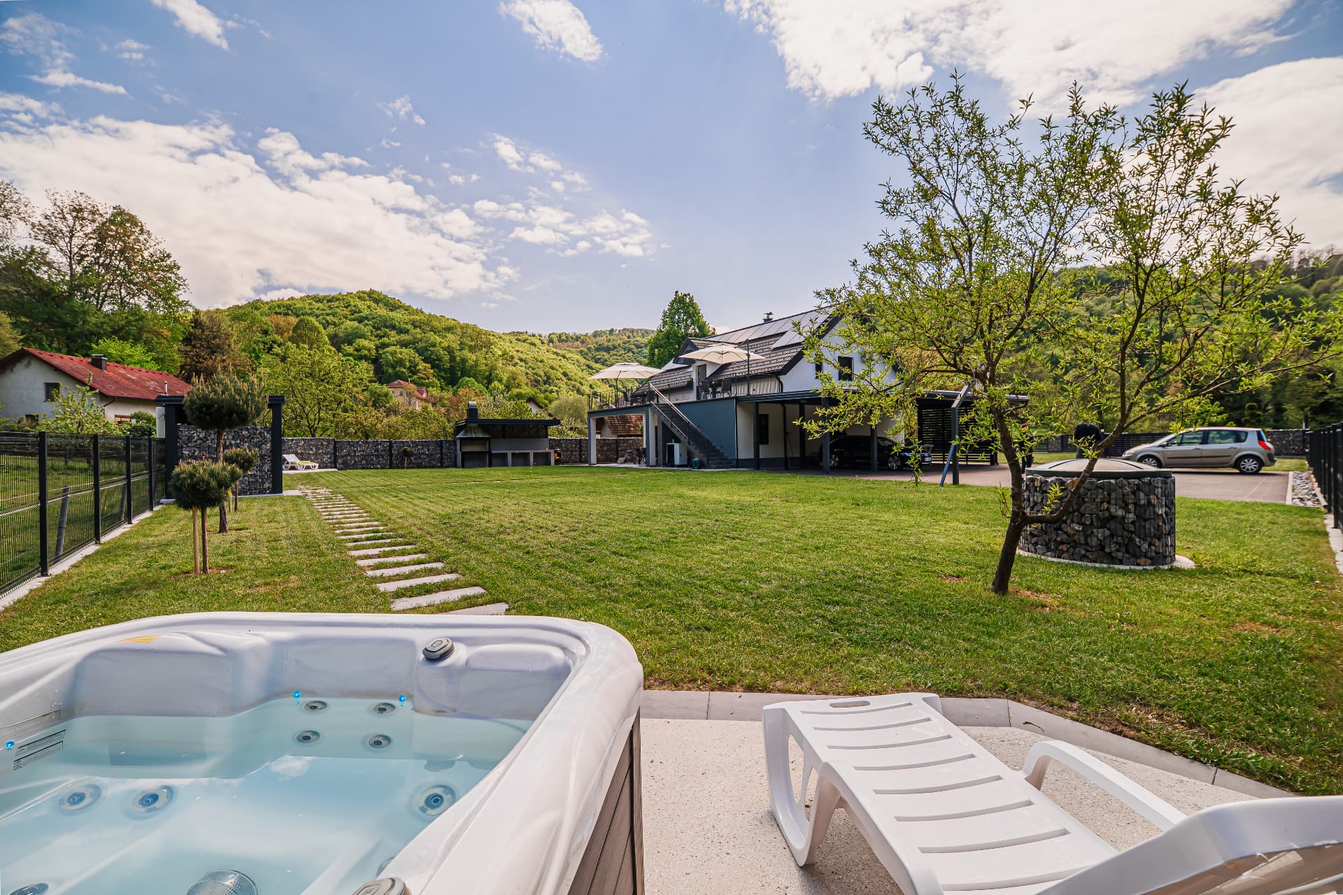 Jacuzzi ob travniku z ležalnikoma