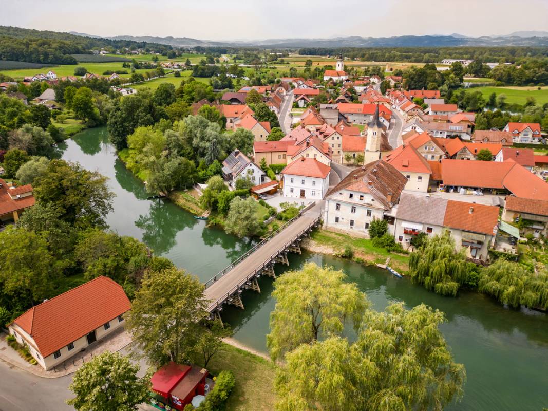 Kostanjevica na Krki z lesenim mostom čez reko Krko