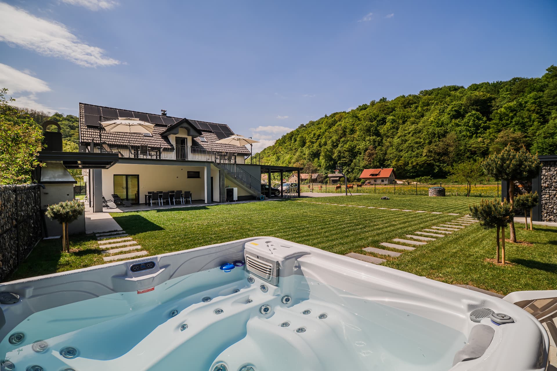 Jacuzzi z razgledom na vilo in gozdnata pobočja